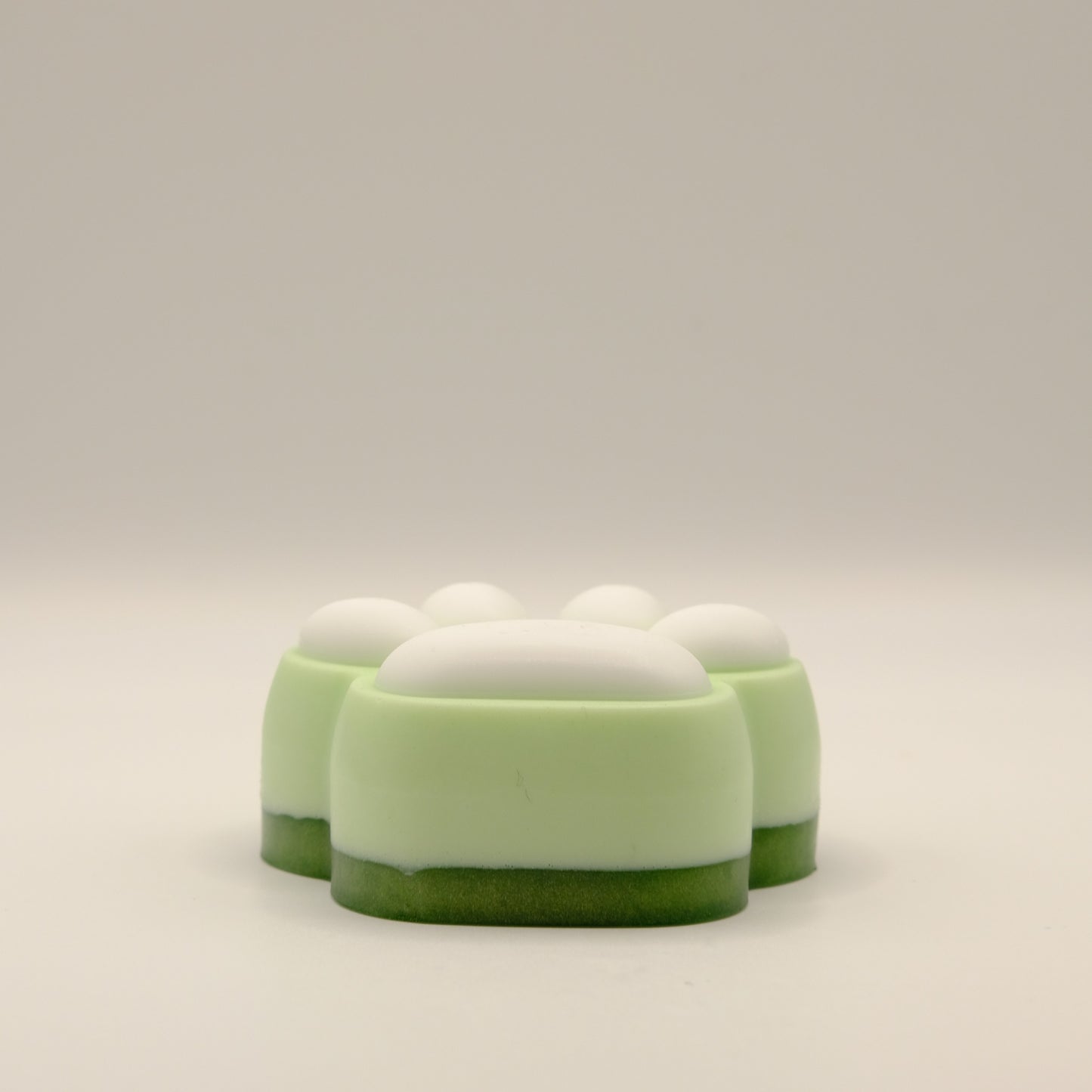 Green and white soap bar with a paw print design on a light gray background
