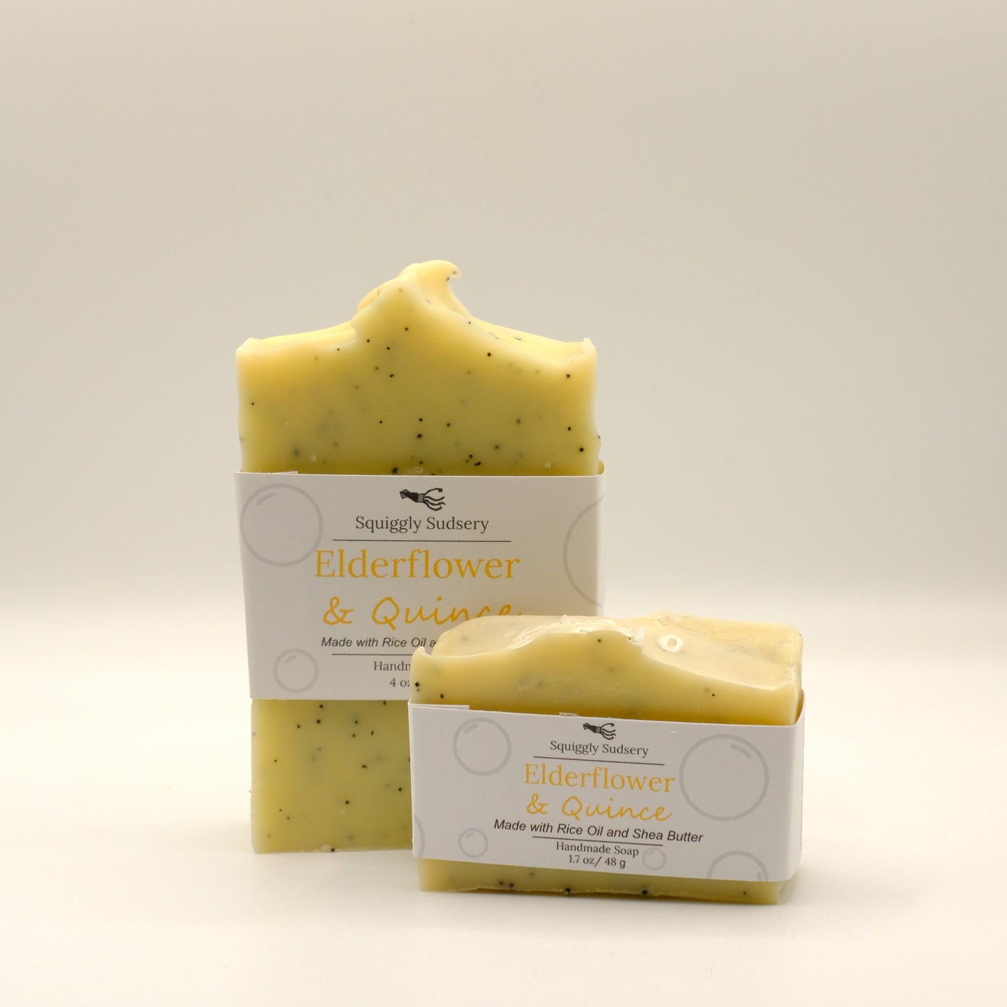 Two yellow bars of soap labeled 'Elderflower and Quince' with a white background
