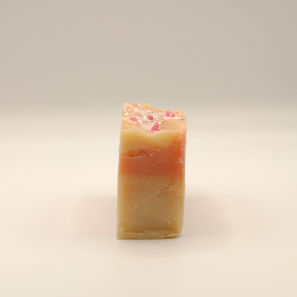 Beige and red bar of soap on a light background.