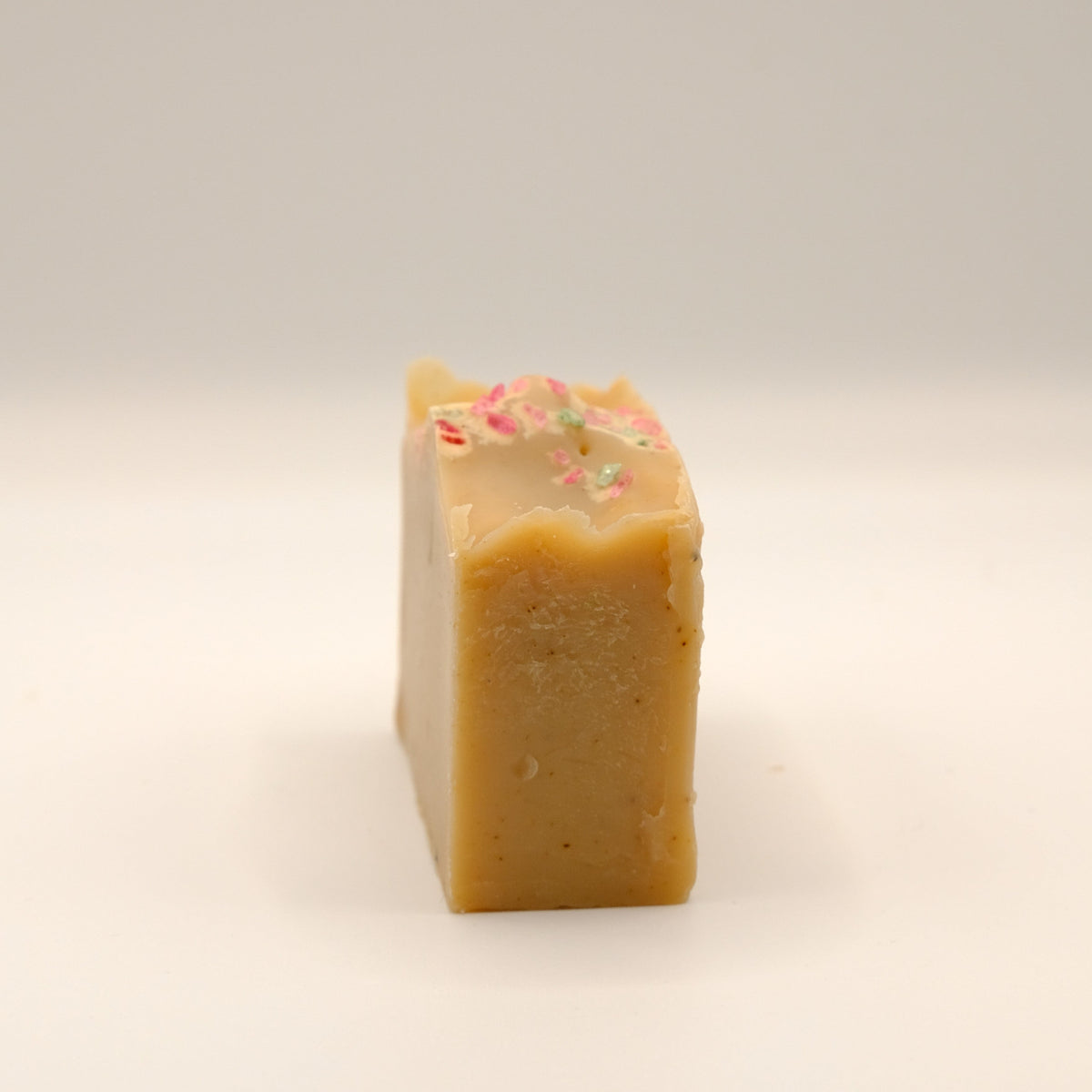 Light brown bar of soap with a textured surface on a light background.