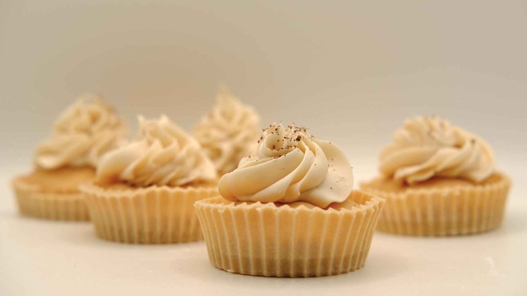 Small cupcakes soaps with creamy frosting on a light background