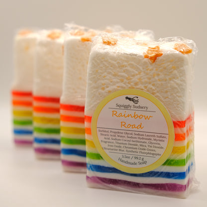 Packaged soap with rainbow stripes and Squiggly Sudsery branding on a light background