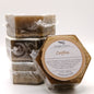 Four hexagonal bars of coffee-scented handmade soap with a label on a white background