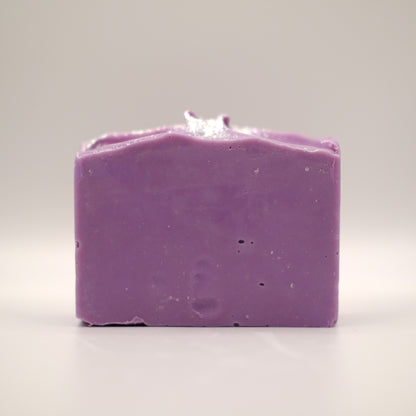 Purple soap bar with a textured top and silver accents on a light gray background