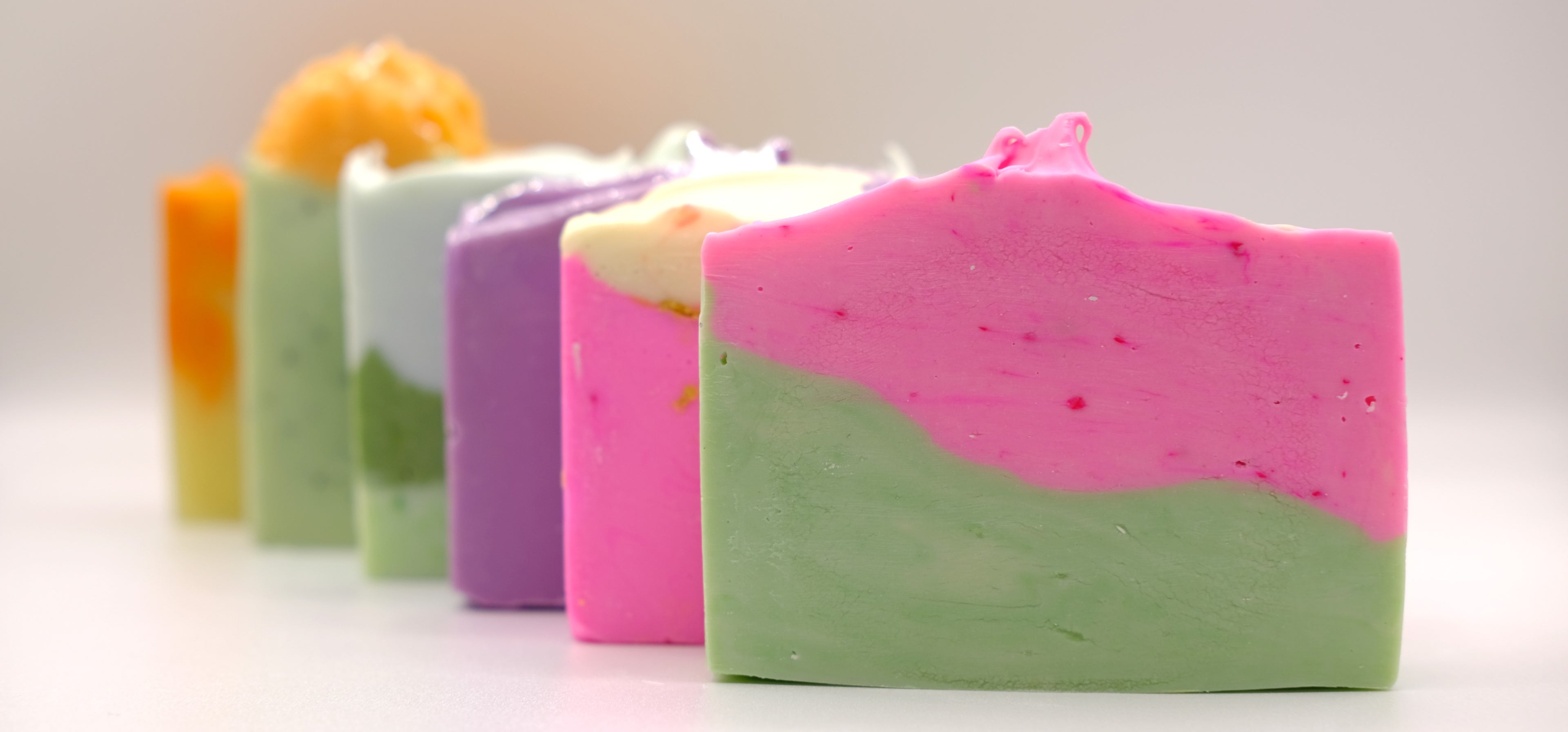 Colorful soap bars arranged in a row on a light background
