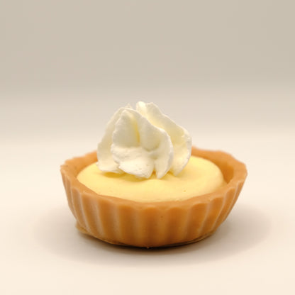 Small lemon tart-shaped soap with whipped cream on a beige background