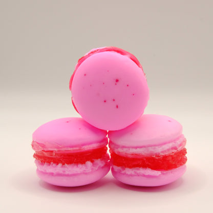 Three pink macaron-shaped soaps on a light gray background