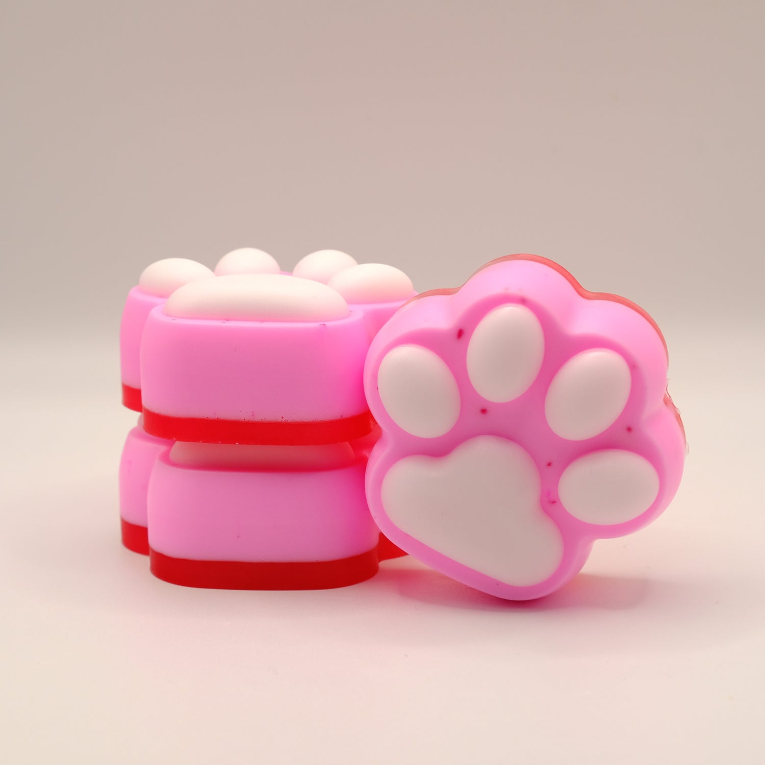 Pink, white and red soap bar with a paw print design on a beige background