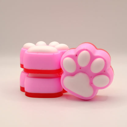 Pink, white and red soap bar with a paw print design on a beige background