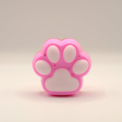 Pink and white soap bar with a paw print design on a beige background