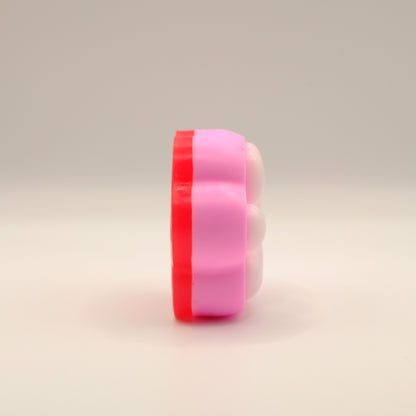 Pink, white and red soap bar with a paw print design on a beige background