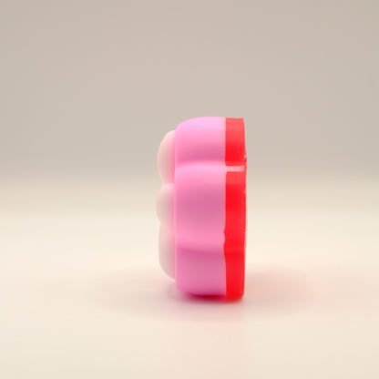 Pink, white and red soap bar with a paw print design on a beige background