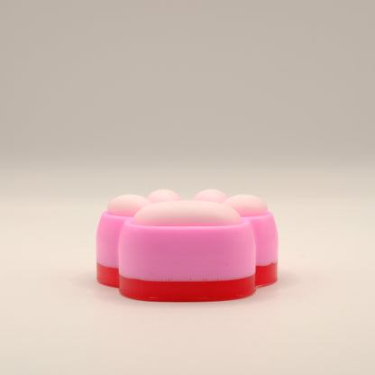 Pink, white and red soap bar with a paw print design on a beige background