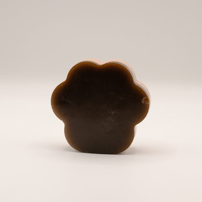 Brown soap bar shaped like a paw print on a beige background