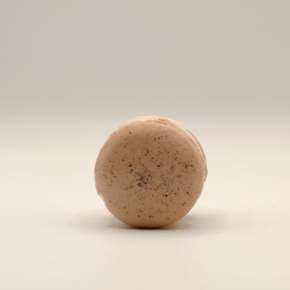 Macaron-shaped soap bar with brown shell on a beige background