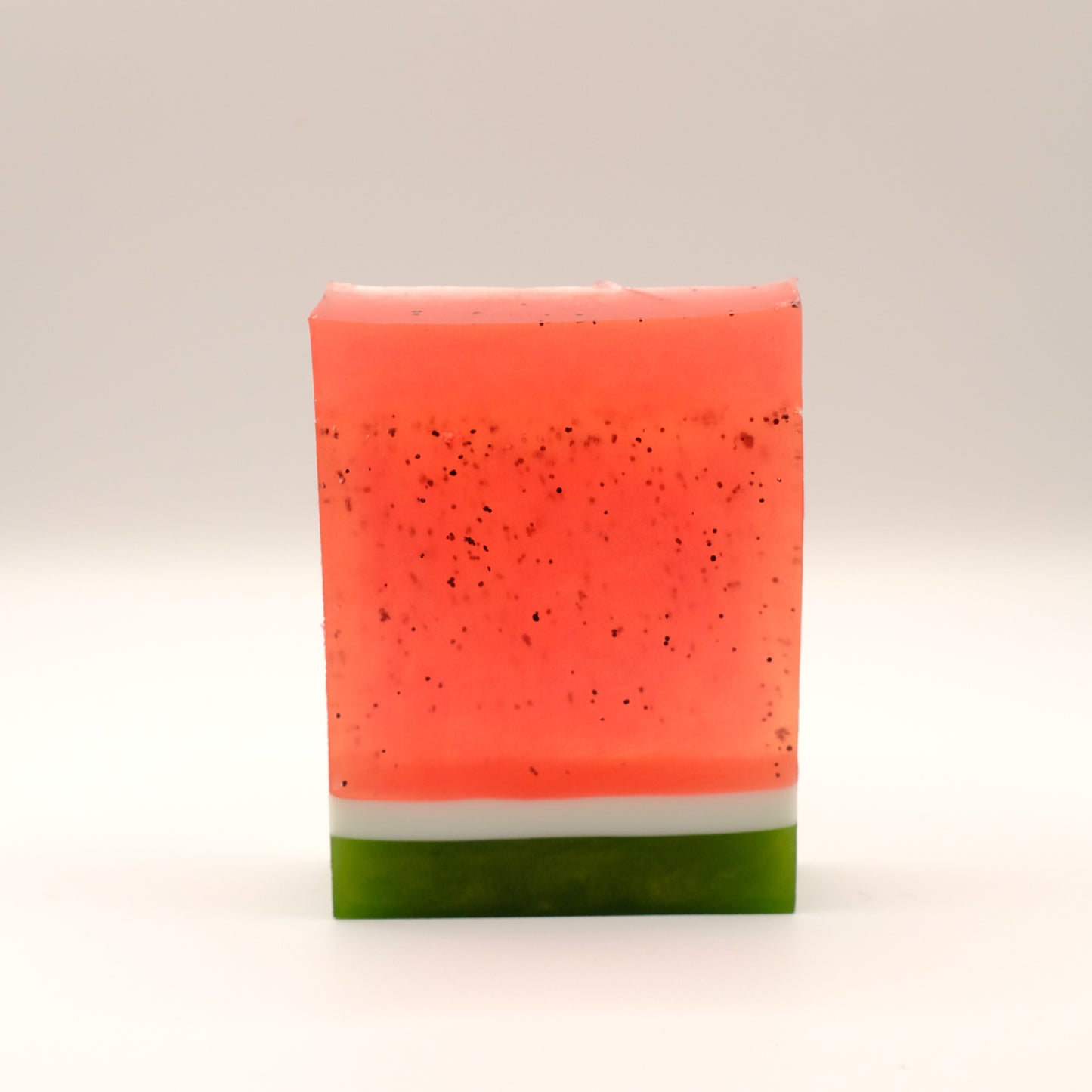 Bar of soap with a red top and green bottom on a light background