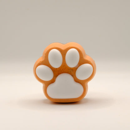 Orange and white paw-shaped soap bar on a beige background