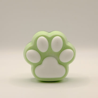 Green and white soap bar with a paw print design on a light gray background