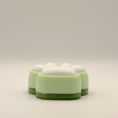 Green and white soap bar with a paw print design on a light gray background