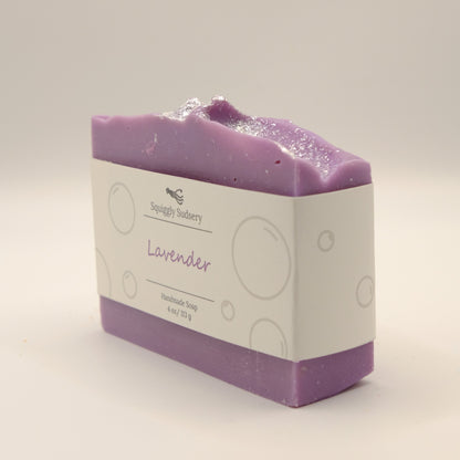 Purple soap bar with a white label on a light gray background