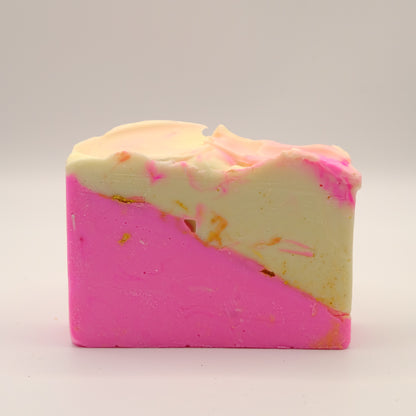 Two-toned pink and beige soap bar with a textured top and gold accents on a white background