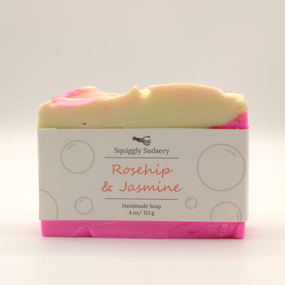 Handmade soap bar with pink and yellow swirls and a label on a white background