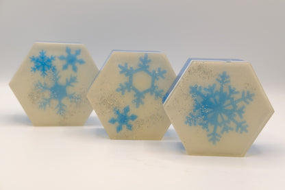Three hexagonal tiles with blue snowflake designs on a light gray background