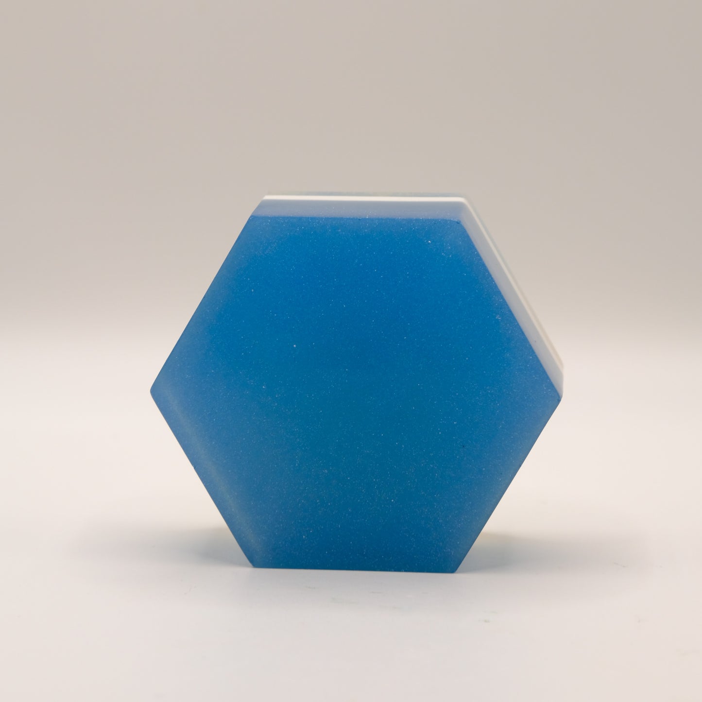 Hexagonal blue bar of soap on a gray background
