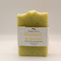 Yellow bar of soap with specks and a label that reads 'Elderflower and Quince' on a light gray background
