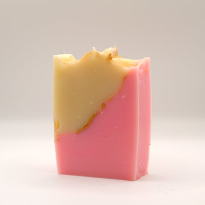 Two-tone beige and pink soap bar with a textured top on a light gray background