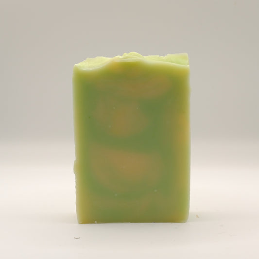 Green and yellow swirled soap bar with a textured top on a white background