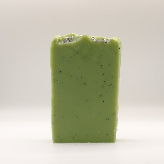 Green soap bar with specks on a white background
