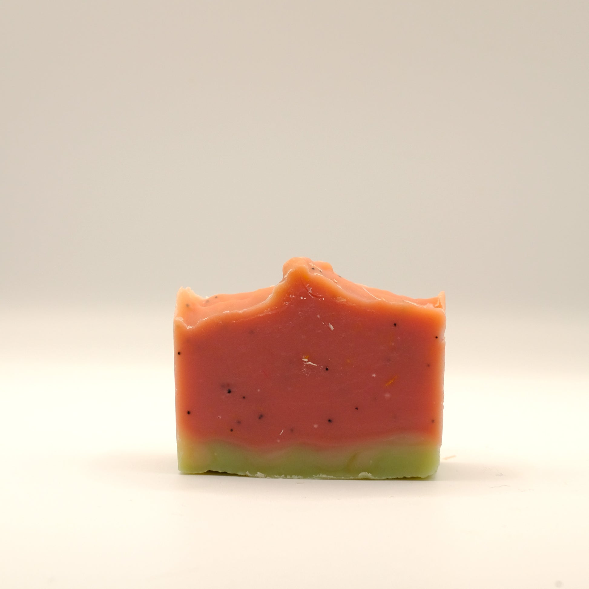 Two-layered soap bar with red and green colors on a white background