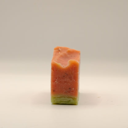 Rectangular bar of soap with a gradient from red to green on a beige background