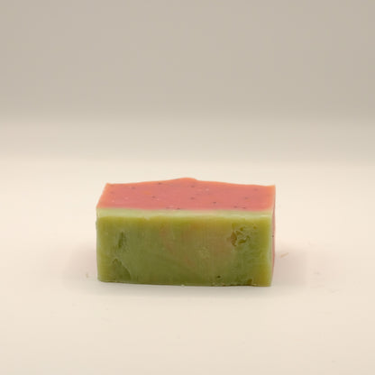 Two-tone green and pink soap bar on a beige background