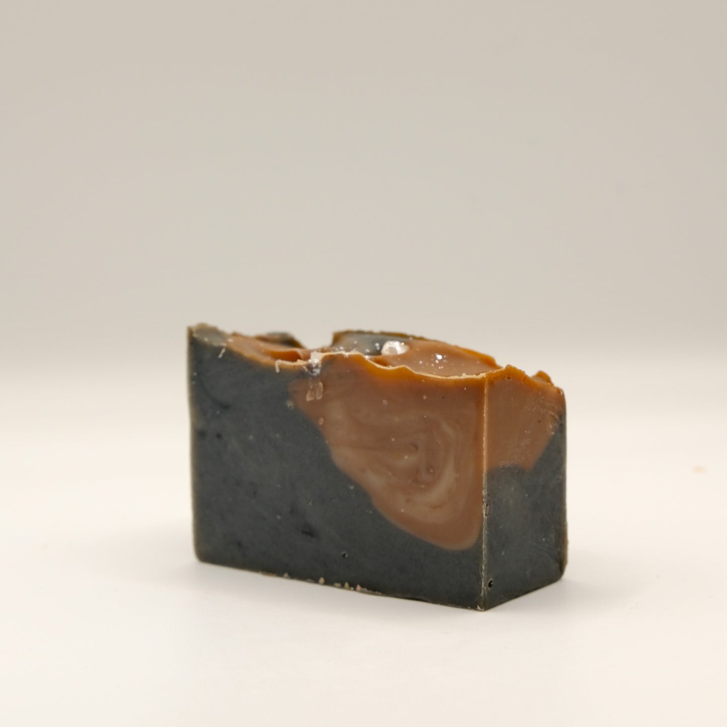 Two-tone soap bar with brown and black colors on a white background