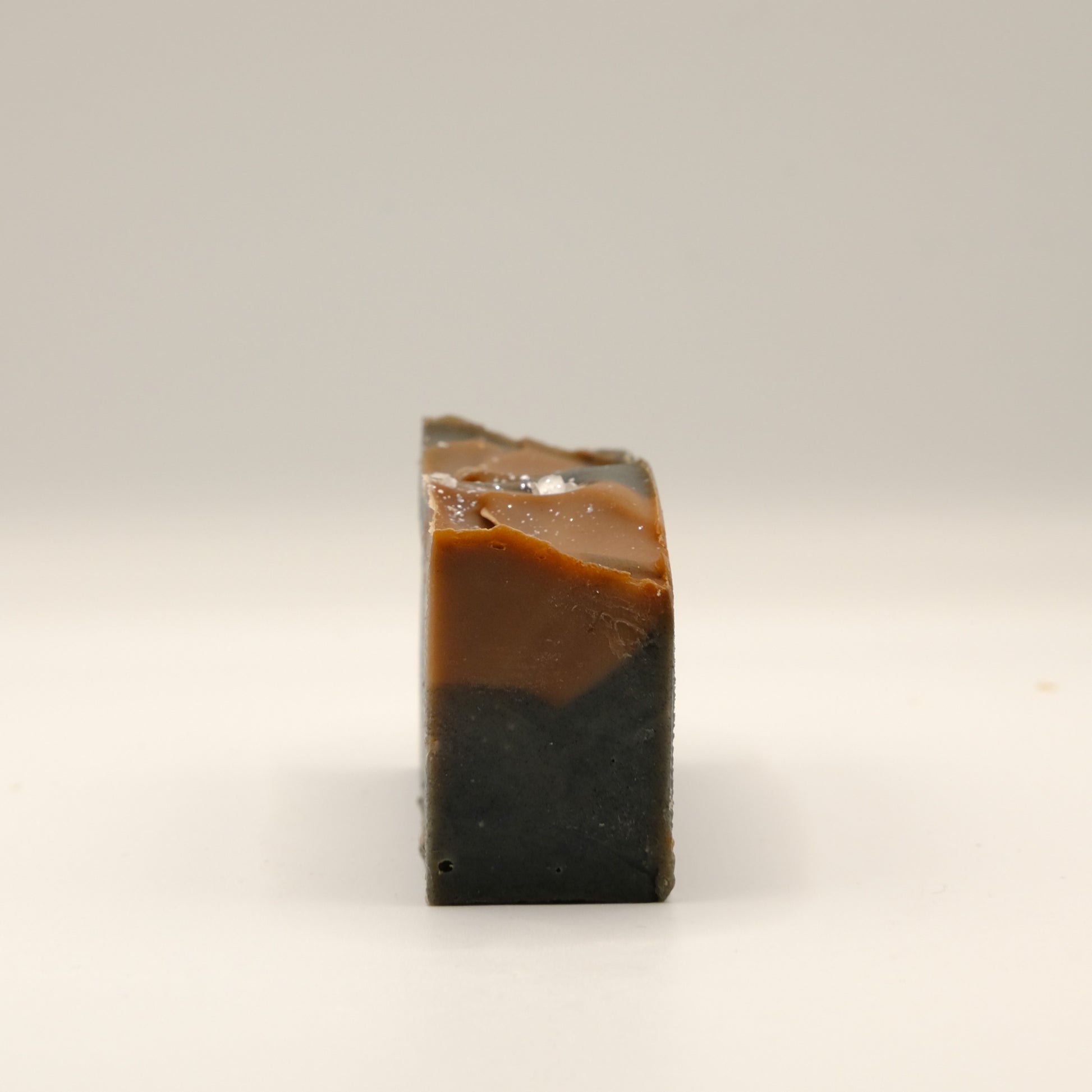 Two-tone brown soap bar on a light beige background