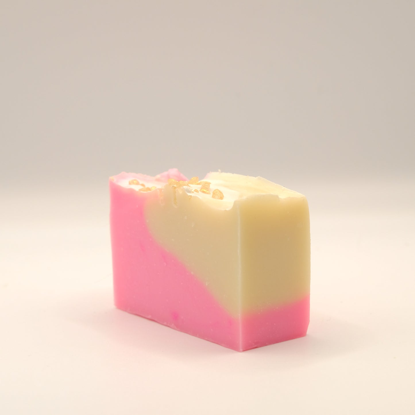 three quarter view of a two-tone pink and beige soap bar on a light background