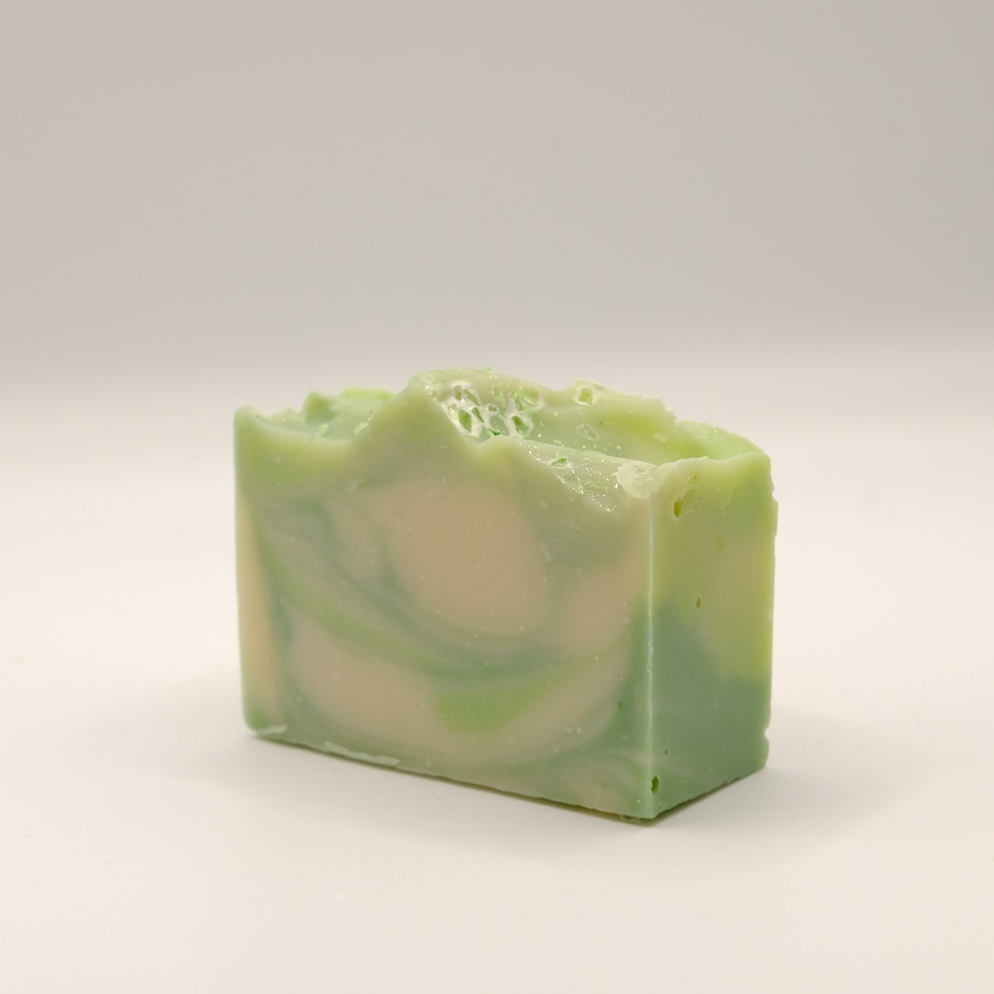 Green and white swirled soap bar on a light background