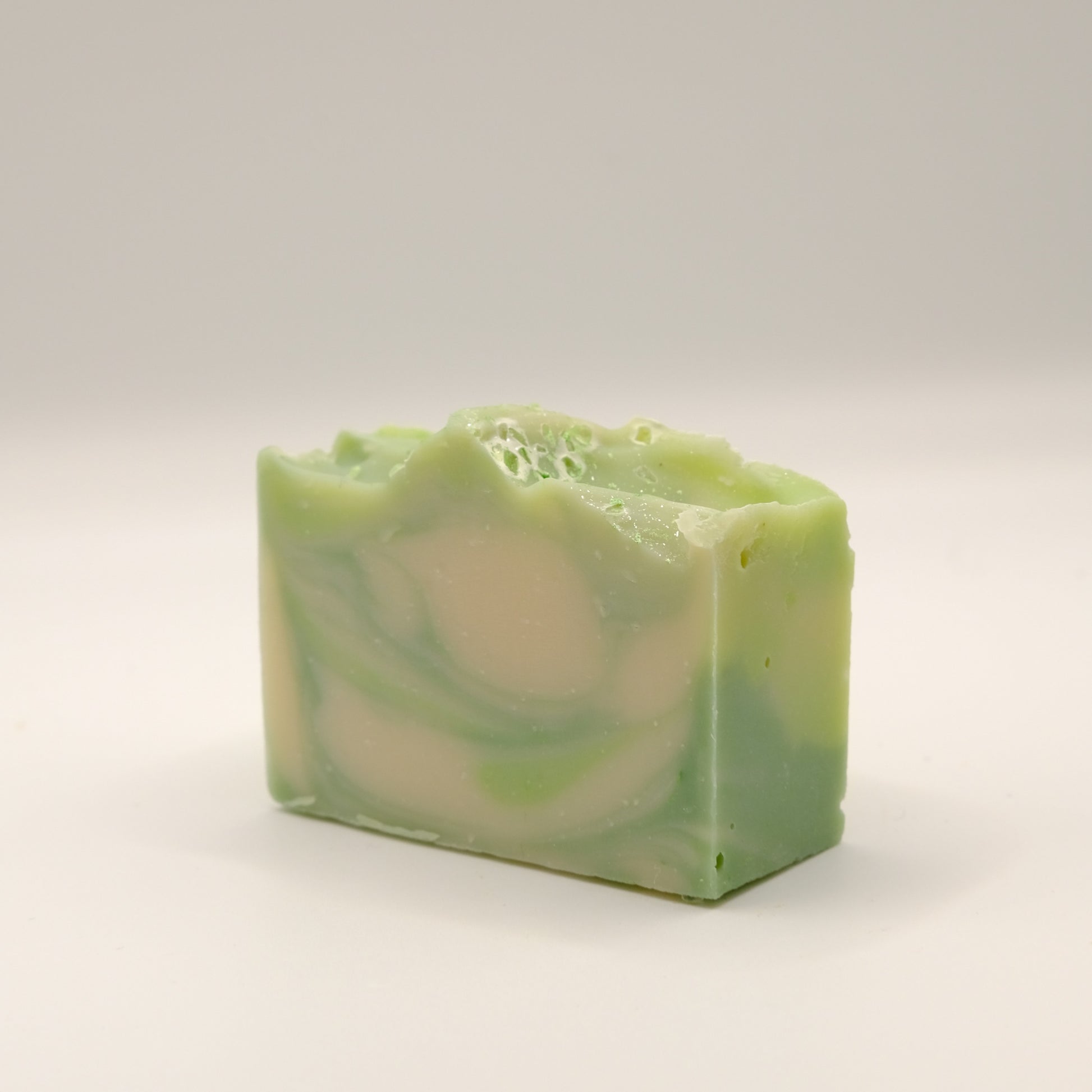 Green and white swirled soap bar on a light background