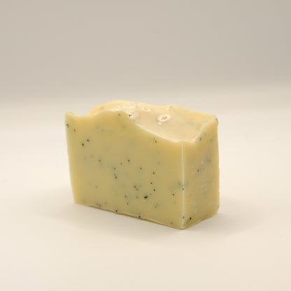 Yellow bar of soap with specks on a light background