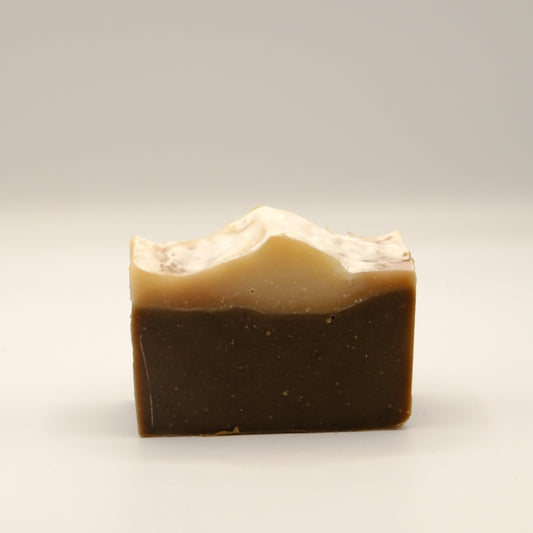 Two-layered soap bar with a dark bottom and light top on a white background
