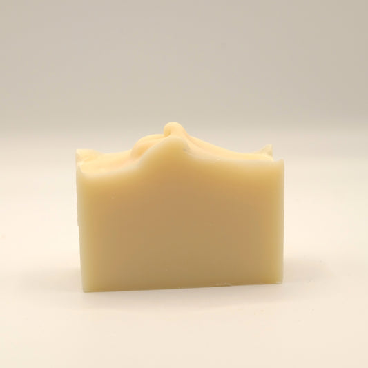 Beige soap bar with a textured top on a light beige background