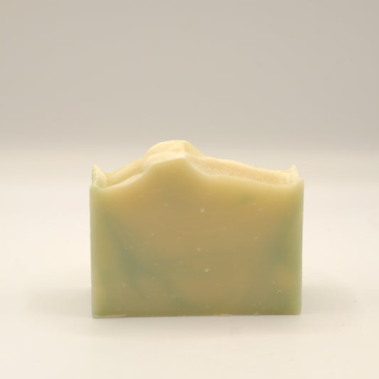 Bar of soap with a yellow and green swirl on a light gray background