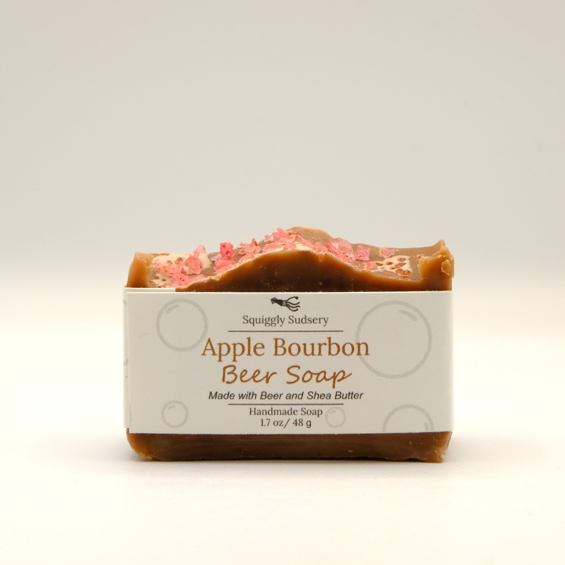 Brown bar of Apple Bourbon Beer Soap with packaging on a light background