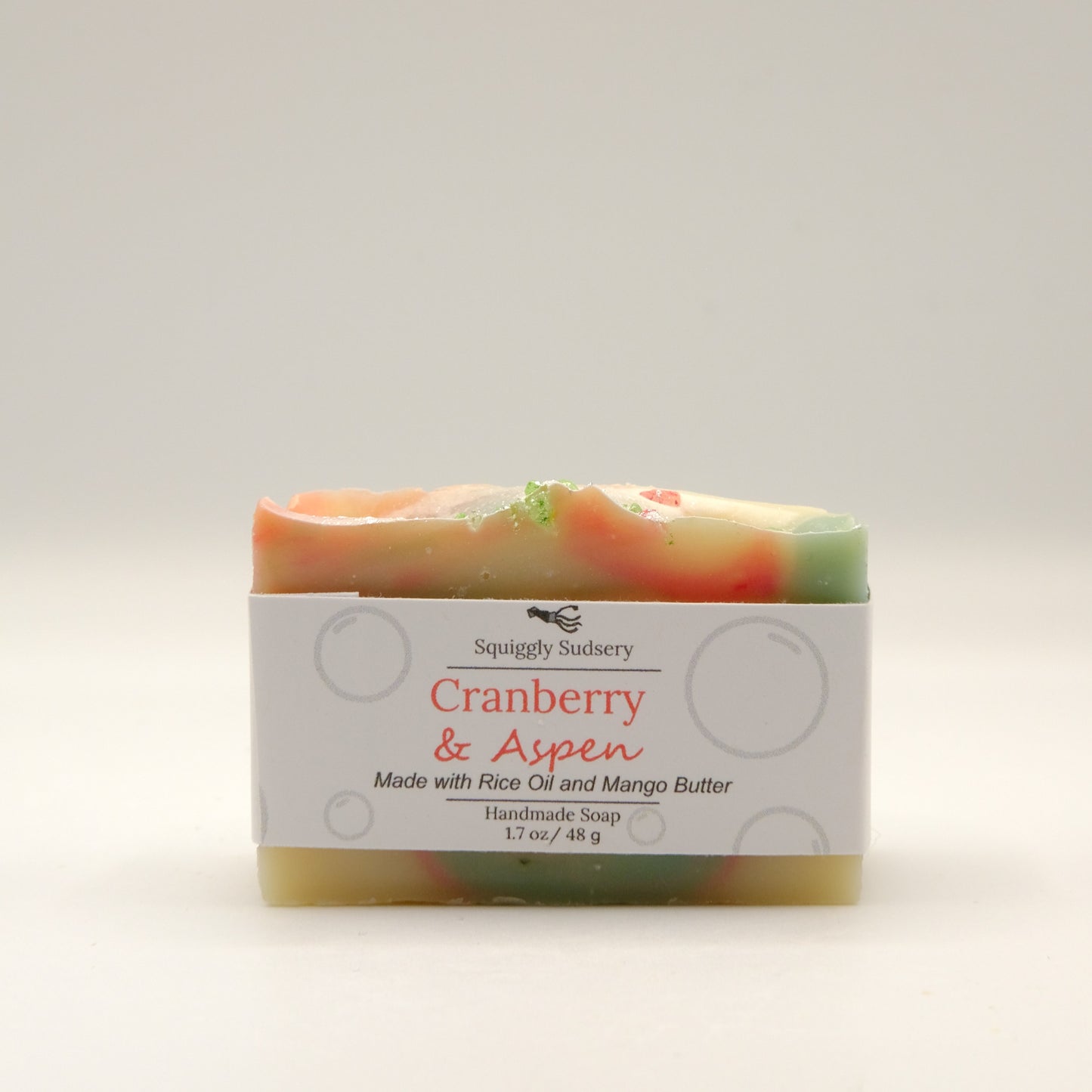 Red, Green and beige bar of soap with 'Cranberry & Aspen' label on a white background