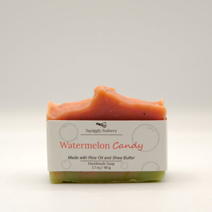 Bar of watermelon candy soap with a white label on a light background
