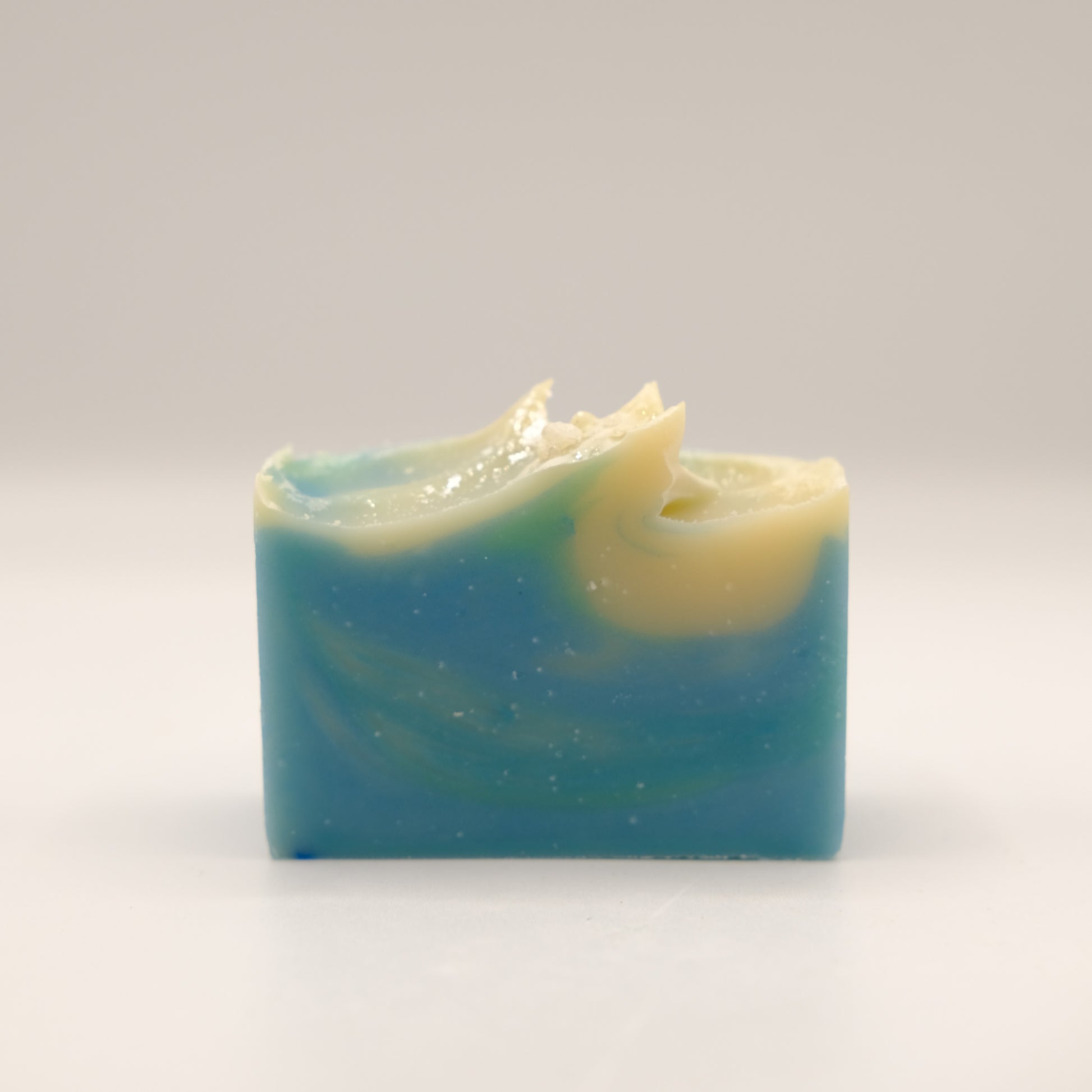 Bar of soap with blue and green swirls on a white background