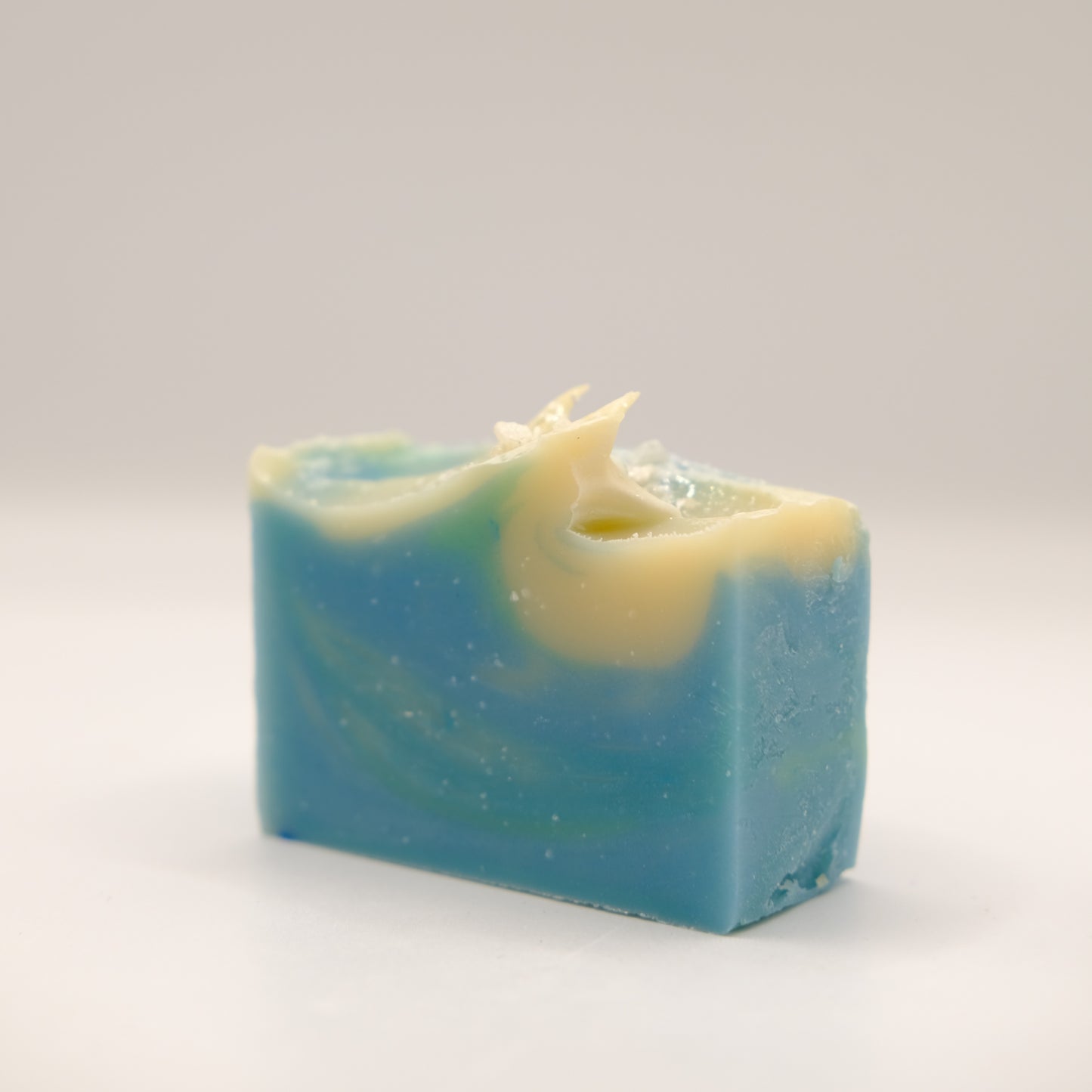 Blue and green swirled soap bar on a light gray background