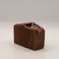 Dark brown bar of soap on a white background